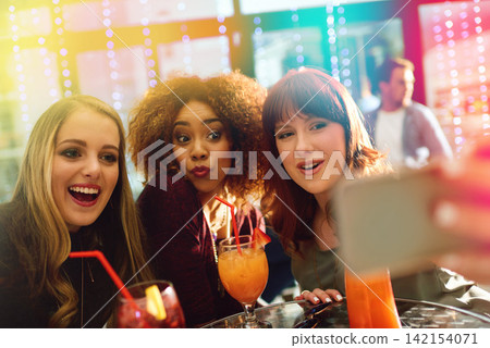 Woman, friends and drinks or party selfie, diversity and fun with alcohol or cocktails in club for entertainment. Smartphone, happy and online for social media post, technology and celebration Woman, friends and drinks or party selfie, diversity and fun with alcohol or cocktails in club for entertainment. Smartphone, happy and online for social media post, technology and celebration 142154071