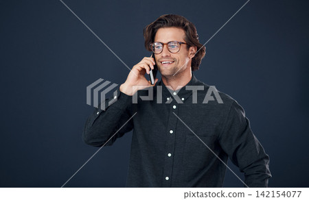 Happy man, glasses and talking with phone call in discussion or communication on a dark studio background. Handsome, geek or male person speaking on mobile smartphone for conversation on mockup space Happy man, glasses and talking with phone call in discussion or communication on a dark studio background. Handsome, geek or male person speaking on mobile smartphone for conversation on mockup space 142154077