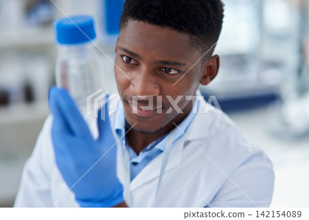 Science, research and black man with container, chemical or medical engineering in laboratory. Biotech, scientist or lab technician with liquid solution in vaccine study for pharmaceutical innovation Science, research and black man with container, chemical or medical engineering in laboratory. Biotech, scientist or lab technician with liquid solution in vaccine study for pharmaceutical innovation 142154089