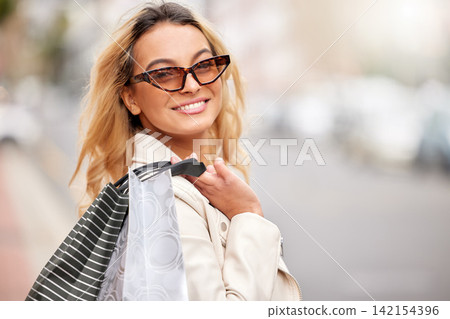 Fashion, shopping bag and portrait of woman in city with sunglasses, retail therapy and financial freedom. Smile, walking and happy girl in street with package for discount sale at designer boutique. Fashion, shopping bag and portrait of woman in city with sunglasses, retail therapy and financial freedom. Smile, walking and happy girl in street with package for discount sale at designer boutique. 142154396