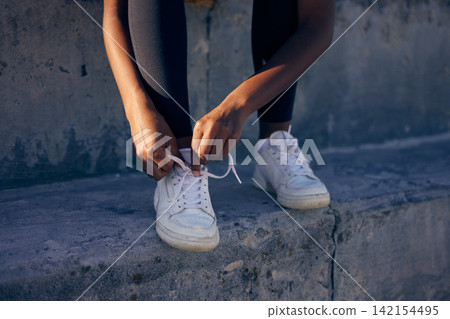 Hands, fitness and tie shoes outdoor at steps to start workout, training or exercise in city. Sneakers, runner and person tying lace to prepare for sports, health or legs ready for wellness at stairs Hands, fitness and tie shoes outdoor at steps to start workout, training or exercise in city. Sneakers, runner and person tying lace to prepare for sports, health or legs ready for wellness at stairs 142154495