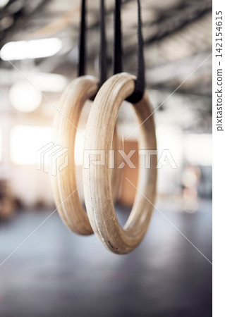 Gymnastic rings, gym and workout for exercise, fitness and strong or power challenge for training. Equipment, tool and flexibility harness or sports for wellness, arena and gear for competition Gymnastic rings, gym and workout for exercise, fitness and strong or power challenge for training. Equipment, tool and flexibility harness or sports for wellness, arena and gear for competition 142154615