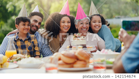 Big family, photography and birthday party for happy outdoor celebration and online memory with cake. Parents, grandmother and kids in backyard for social event in garden and festive hat with dessert Big family, photography and birthday party for happy outdoor celebration and online memory with cake. Parents, grandmother and kids in backyard for social event in garden and festive hat with dessert 142154674