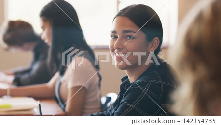 High school, student and portrait in classroom for education course with knowledge, academic or scholarship. Girl, desk and face at learning academy on campus for future studying, lecture or happy High school, student and portrait in classroom for education course with knowledge, academic or scholarship. Girl, desk and face at learning academy on campus for future studying, lecture or happy 142154735