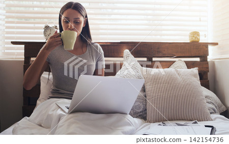 Bedroom, coffee and woman with laptop for remote work, relax and research for online career. Thinking, reading and freelancer girl in bed with computer checking email, web review and drink in home. Bedroom, coffee and woman with laptop for remote work, relax and research for online career. Thinking, reading and freelancer girl in bed with computer checking email, web review and drink in home. 142154736