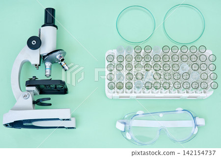 Lab, tools and collection of equipment with microscope, test tube and safety goggles for medical research. Science, medicine and laboratory supplies for pharmaceutical study on studio background. Lab, tools and collection of equipment with microscope, test tube and safety goggles for medical research. Science, medicine and laboratory supplies for pharmaceutical study on studio background. 142154737