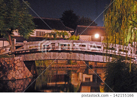 黃昏時的倉敷美學區,石橋和復古的街景倒映在水面上。 黃昏時的倉敷美學區,石橋和復古的街景倒映在水面上。 142155166