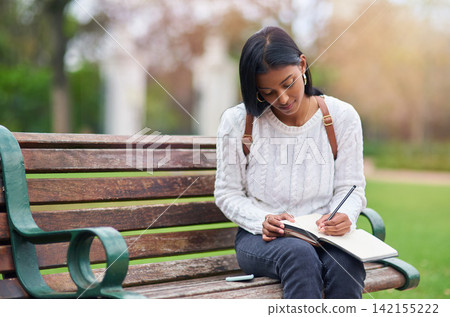 Indian girl, student and writing notes at park for education, learning or studying at university on bench in garden. Notebook, serious and woman at outdoor campus for knowledge, information or course Indian girl, student and writing notes at park for education, learning or studying at university on bench in garden. Notebook, serious and woman at outdoor campus for knowledge, information or course 142155222