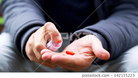 Hands, man and pill box for drugs in outdoors, disease and aspirin for pain or capsule for health. Container, palm and vitamin or antibiotics for treatment, medicine and prescription tablets for dose Hands, man and pill box for drugs in outdoors, disease and aspirin for pain or capsule for health. Container, palm and vitamin or antibiotics for treatment, medicine and prescription tablets for dose 142155223