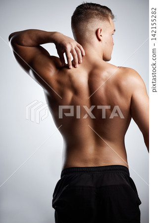 Bodybuilder, flex and back with muscle in studio for fitness, training and strong from exercise. Healthy, person and model stretching arms on background or mockup with wellness from workout in gym Bodybuilder, flex and back with muscle in studio for fitness, training and strong from exercise. Healthy, person and model stretching arms on background or mockup with wellness from workout in gym 142155282