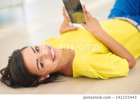 Portrait, woman and floor at home with tablet for communication with family on digital technology in living room. Happy, female person and relaxing alone for weekend break with social media website 142155443