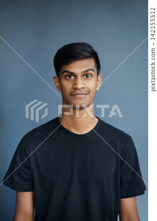 Studio, portrait and smile of Indian student, confidence and guy with tshirt, fashion and college. University, gen z and male person, school and blue background, pride and face of model and yearbook 142155512