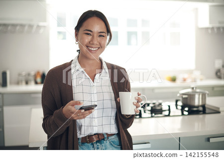 Portrait, Asian woman or coffee to relax, phone or browse on social media, website or app in kitchen. Gen z girl, smile or smartphone to drink, tea or update of post to connect at weekend of leisure Portrait, Asian woman or coffee to relax, phone or browse on social media, website or app in kitchen. Gen z girl, smile or smartphone to drink, tea or update of post to connect at weekend of leisure 142155548