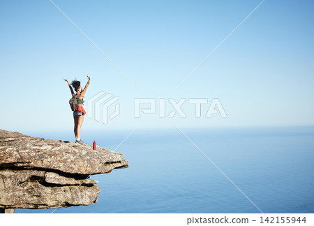 Woman, success and open arms on mountain cliff for freedom, achievement and explore in nature. Hiking, exercise and wellness with ocean, view and cardio for female hiker in for adventure on mockup Woman, success and open arms on mountain cliff for freedom, achievement and explore in nature. Hiking, exercise and wellness with ocean, view and cardio for female hiker in for adventure on mockup 142155944