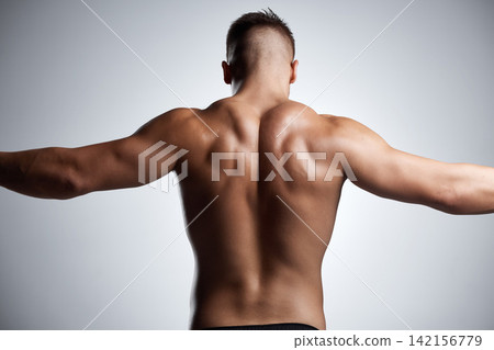 Back, flex and bodybuilder in studio with muscle, fitness and strong from training or exercise. Healthy, person and model stretching arms on background or mockup with wellness from workout in gym Back, flex and bodybuilder in studio with muscle, fitness and strong from training or exercise. Healthy, person and model stretching arms on background or mockup with wellness from workout in gym 142156779