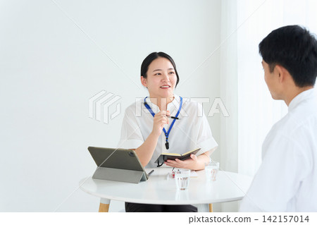 A female staff member and a man explain. A female staff member and a man explain. 142157014