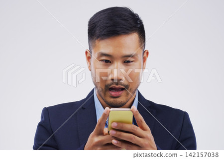 Asian man, smartphone and surprised in studio for social media, text and secret on white background. Reading, cellphone and male person on internet for wow, gossip and fake news or watch video online Asian man, smartphone and surprised in studio for social media, text and secret on white background. Reading, cellphone and male person on internet for wow, gossip and fake news or watch video online 142157038