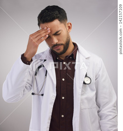 Studio, man or doctor in pain of headache, burnout and mental health of medical employee. Tired, healthcare male worker and stress with migraine, anxiety and overworked pressure by white background 142157109
