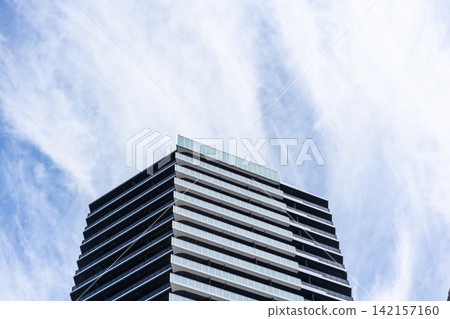 Low angle view of modern residential building with balconies under cloudy sky in Fukuoka, Japan Low angle view of modern residential building with balconies under cloudy sky in Fukuoka, Japan 142157160