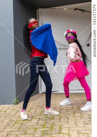 African American girls teen and child posing in driveway in blue cape, pink tutu, purple sunglasses 142157374