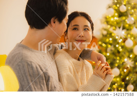 聖誕節當天,一對夫婦在客廳放鬆休息。 聖誕節當天,一對夫婦在客廳放鬆休息。 142157588