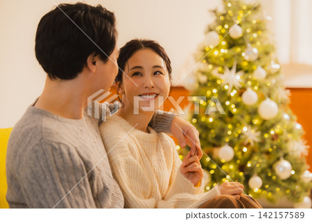 聖誕節當天,一對夫婦在客廳放鬆休息。 聖誕節當天,一對夫婦在客廳放鬆休息。 142157589