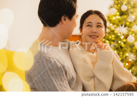 聖誕節當天,一對夫婦在客廳放鬆休息。 聖誕節當天,一對夫婦在客廳放鬆休息。 142157595