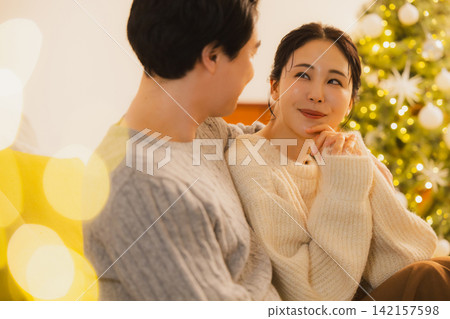 聖誕節當天,一對夫婦在客廳放鬆休息。 聖誕節當天,一對夫婦在客廳放鬆休息。 142157598