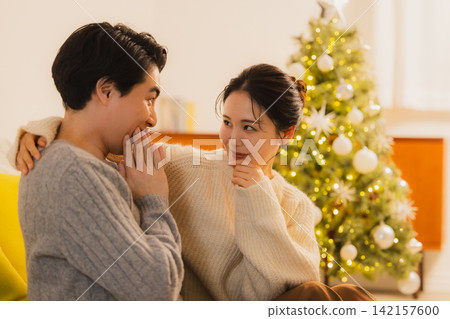 聖誕節當天,一對夫婦在客廳放鬆休息。 聖誕節當天,一對夫婦在客廳放鬆休息。 142157600
