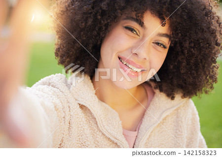 Woman, portrait and smile for selfie with confidence outside in nature with closeup. Student, campus and college with spontaneous picture for social media with happiness, afro and positive in London Woman, portrait and smile for selfie with confidence outside in nature with closeup. Student, campus and college with spontaneous picture for social media with happiness, afro and positive in London 142158323