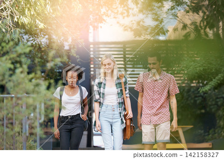 Walking, conversation and young students at university planning for study, assignment or test. Networking, discussion and diversity friends with bags bonding and talking at college campus together. Walking, conversation and young students at university planning for study, assignment or test. Networking, discussion and diversity friends with bags bonding and talking at college campus together. 142158327