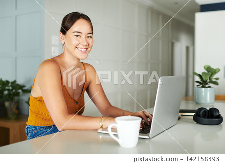 Laptop, coffee and portrait of woman in kitchen working on creative freelancer project at home. Technology, smile and Asian female with research on computer with cappuccino by counter at apartment. 142158393