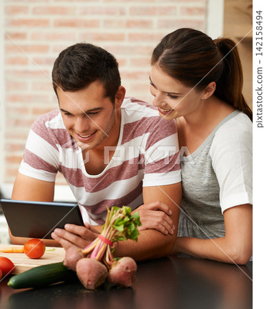 Cooking recipe, tablet and couple in kitchen for healthy food or vegetables for lunch or dinner tutorial. Online, steps and woman in meal prep for salad preparation or hungry vegan man in England Cooking recipe, tablet and couple in kitchen for healthy food or vegetables for lunch or dinner tutorial. Online, steps and woman in meal prep for salad preparation or hungry vegan man in England 142158494