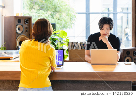 Entrepreneurs and team members brainstorm ideas while viewing data on screens in an open office. Entrepreneurs and team members brainstorm ideas while viewing data on screens in an open office. 142158520