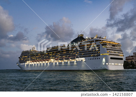 Cruise ship vacation and travel at sea. View of illuminated luxury liner. Ship at night port. Luxury sea vacation. Cruise ship vacation. Majestic cruise ship in vacation summer. Ocean Cruises 142158807