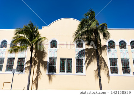 Apartment building with balconies and palm trees. Low angle view of building. Residential resort building architecture. Architectural exterior. House exterior fragment. Modern apartment building Apartment building with balconies and palm trees. Low angle view of building. Residential resort building architecture. Architectural exterior. House exterior fragment. Modern apartment building 142158839