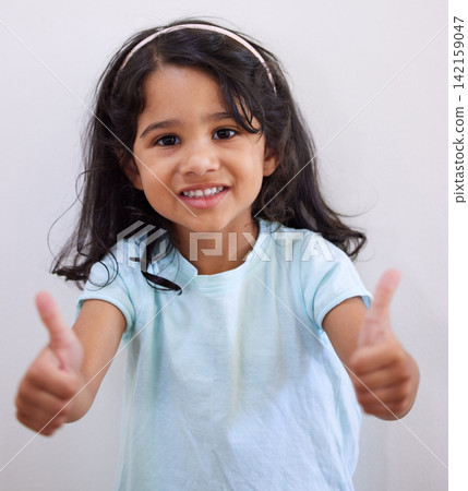 Girl, child and thumbs up by wall in portrait for like, choice and agreement with smile in family home. Kid, happy and hands for sign language, symbol and trendy fashion with decision in Bogota 142159047