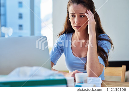 Home, woman and laptop with stress on internet or online for research, illnes and results. Female person, worried and headache with medication or pills as prescription for sickness and information Home, woman and laptop with stress on internet or online for research, illnes and results. Female person, worried and headache with medication or pills as prescription for sickness and information 142159106