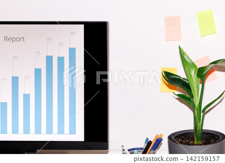 Workspace with data visualization on screen and plant decor Workspace with data visualization on screen and plant decor 142159157