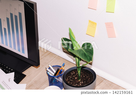 Desk with monitor, plant, pens, and notes Desk with monitor, plant, pens, and notes 142159161