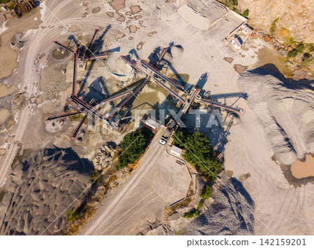 Granite quarry with machinery and piles of stone in the area during daytime Granite quarry with machinery and piles of stone in the area during daytime 142159201