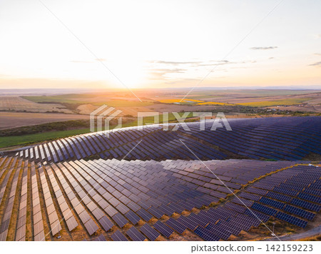 Solar panels cover fields at sunset in a rural area, showing the shift to renewable energy sources Solar panels cover fields at sunset in a rural area, showing the shift to renewable energy sources 142159223