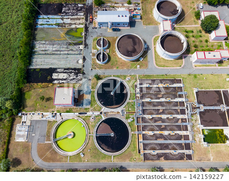 Water treatment facility showing various tanks and sections for processing wastewater at a specific location Water treatment facility showing various tanks and sections for processing wastewater at a specific location 142159227