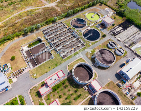 Water treatment facility located near a city helps clean and manage wastewater during the day Water treatment facility located near a city helps clean and manage wastewater during the day 142159229
