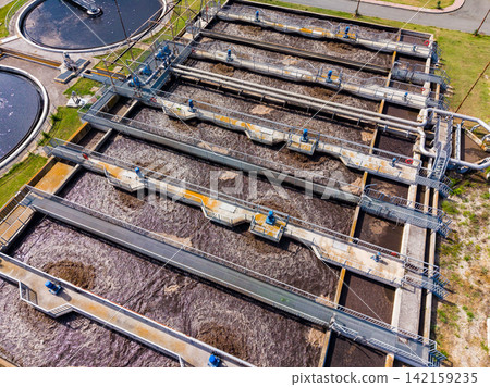 Water treatment facility uses large tanks and channels to clean wastewater during the day 142159235