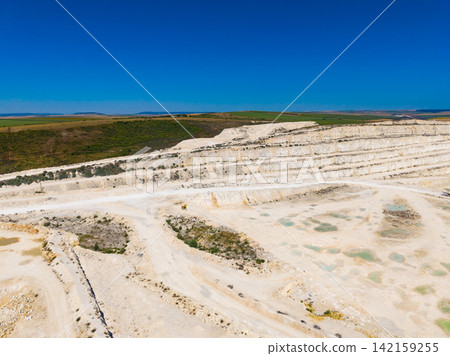 White quarry site with layered stone and blue sky in the background White quarry site with layered stone and blue sky in the background 142159255