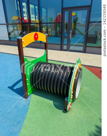 Playground equipment with a colorful design and a large tube located in a children's play area on a sunny day Playground equipment with a colorful design and a large tube located in a children's play area on a sunny day 142159348