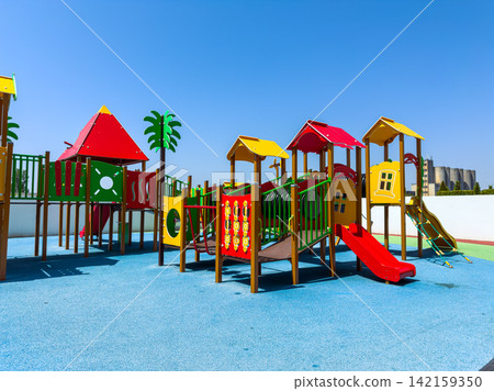 Playground structure in a sunny outdoor area with equipment for children to explore and play during the day Playground structure in a sunny outdoor area with equipment for children to explore and play during the day 142159350