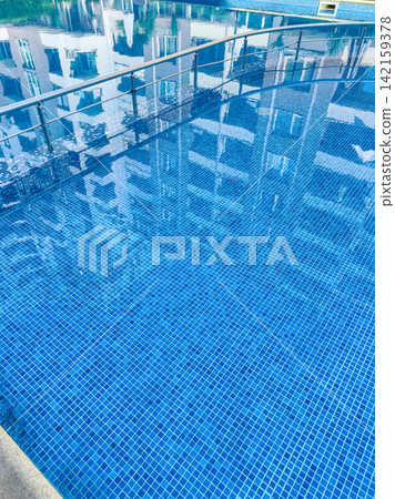 Reflection of buildings in a swimming pool on a bright day in an urban area 142159378