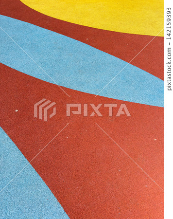 Colorful playground surface with red, blue, and yellow sections and curved shapes in bright patterns Colorful playground surface with red, blue, and yellow sections and curved shapes in bright patterns 142159393